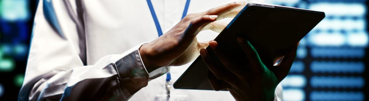 Worker using tablet to do assessments of data center rackmounts doing complex calculations, enabling artificial intelligence to process massive datasets for machine learning and AI workloads, close up